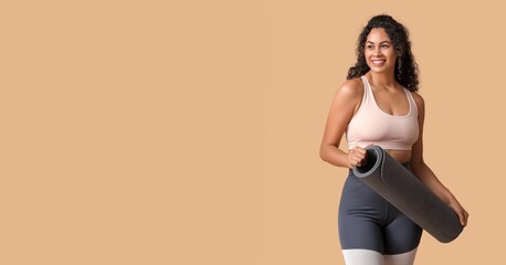 Obraz premium Sporty young African-American woman with yoga mat on beige background with space for text