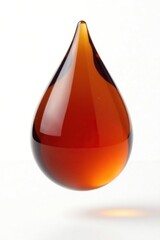 Obraz premium Isolated single droplet of dark brown honey suspended above plain white background, earthy, texture