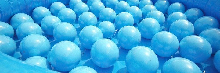 Blue and white balls filled a large inflatable pool, background, blue