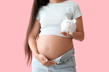 Young pregnant woman with piggy bank on pink background, closeup. Maternal Benefit concept