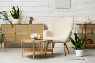 Interior of modern living room with armchair, coffee table and burning candle