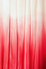 Fototapeta premium Vibrant red and white ombre fabric with flowing texture, creating a serene and elegant visual aesthetic.