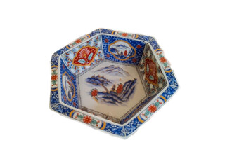 A hexagonal ceramic bowl with colorful floral and landscape patterns.

