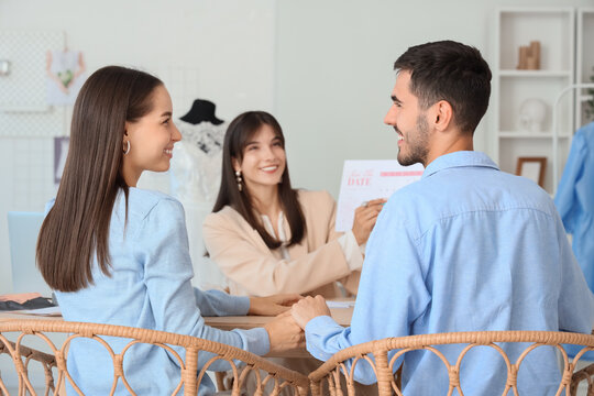 Young couple planning their wedding in office, back view