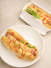 Hotdog with mayonnaise and ketchup drizzled on white background