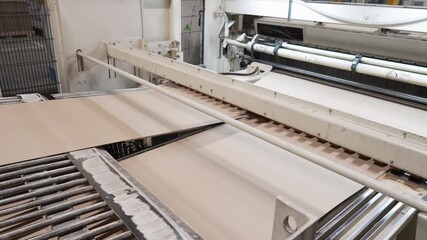 Processing cardboard in a paper mill close-up. Manufacture of corrugated paper and containers of paper and paperboard. Corrugated unit for the production of 2 -, 3-and 5-layer corrugated cardboard
