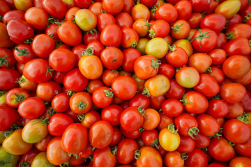 Fresh cherry tomatoes in vibrant red and orange hues, captured in a detailed close-up. Perfectly ripe and ideal for salads, cooking, or food-themed projects
