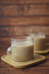 Enjoy a warm cup of coffee served in glass mugs on a rustic wooden background