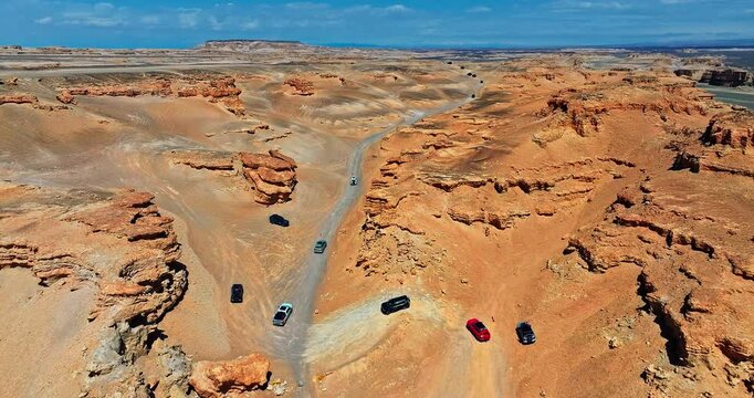Cars pass through the Yardang landform desert road. The famous Dahaidao no man's land natural landscape in Xinjiang, China. A paradise for self driving tours.
