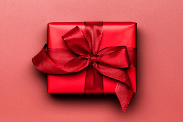 Red gift box with red ribbon, close-up, top view