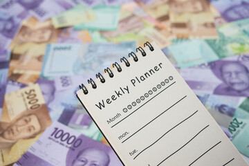 Weekly Planner With Currency Background Representing Financial Planning