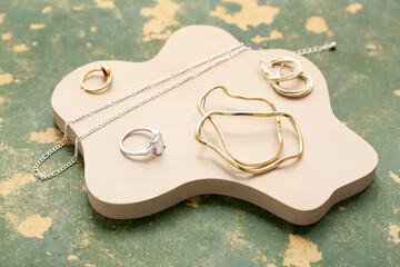 Podium with stylish jewelry on grunge background