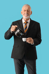 Senior businessman pouring coffee from pot into cup on blue background