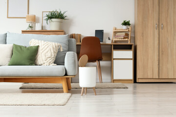 Interior of stylish living room with grey sofa and trash bin