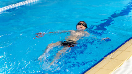 A boy in a swimming pool learns to swim