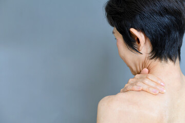 肩こりに悩む中年のアジア人女性