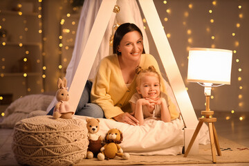 Cute little girl with her mother in hut at home