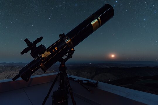 night sky with vast array of stars and glowing galaxy in distance viewed through lens of large telescope