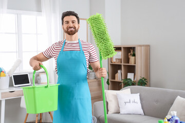 Male janitor with mop and bucket in room