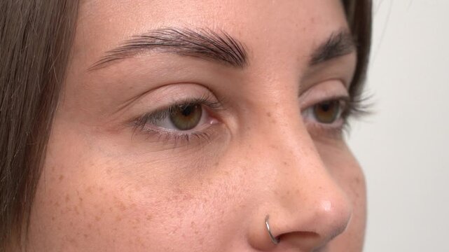 A beautiful young girl opens her eyes after eyelash lamination. Close-up, slow motion