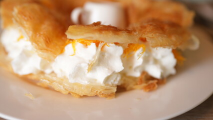 Delicious Creamy Pastry with Whipped Cream and Orange Garnish