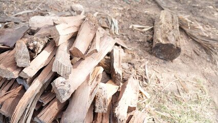 Close-Up View of Neatly Stacked Firewood on Ground Outdoors