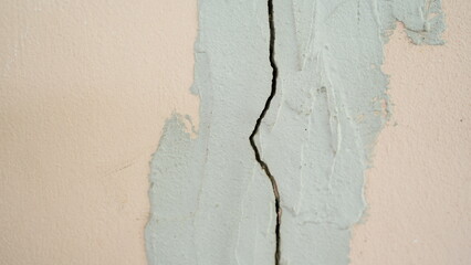 Cracked Wall Surface with Textured Paint Layer in Neutral Tones