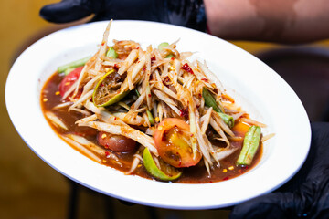 Thai papaya Salad .(SOM TAM) with Crab and Pickled Fish in white plate.