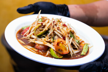 Thai papaya Salad .(SOM TAM) with Crab and Pickled Fish in white plate.
