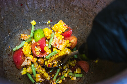 Cheft making Thai papaya salad with corn and fresh shrimp