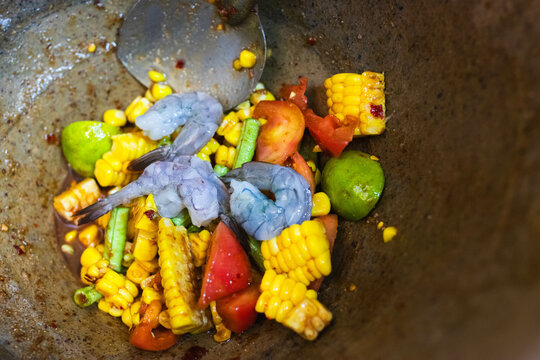 Cheft making Thai papaya salad with corn and fresh shrimp