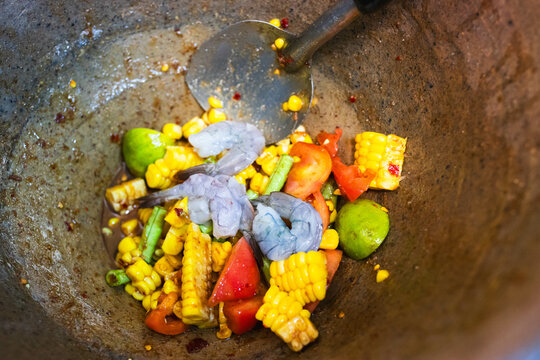 Cheft making Thai papaya salad with corn and fresh shrimp