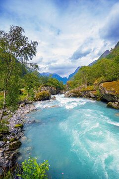 Beautiful mountain river Dalelva (Stryn). Cascade mountain stream with rapids. View from Briksdal Bridge