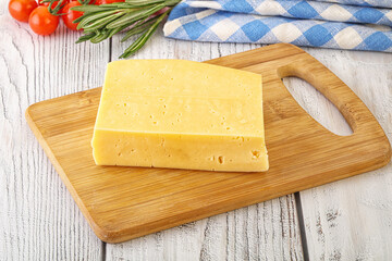Piece of natural organic cheese over board