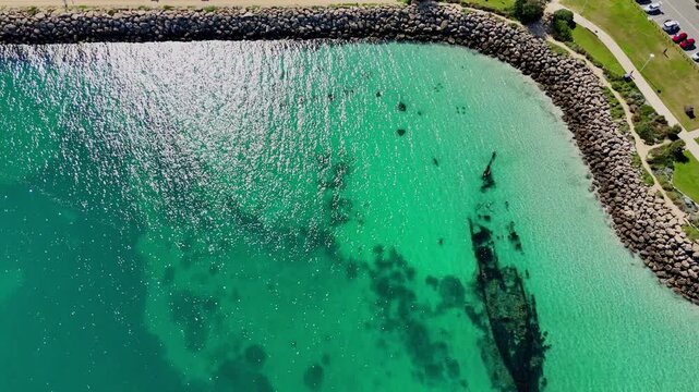 aerial drone shot of Coogee beach and Omeo shipwreck lying in tourquoise waters close to white sand beach of Fremantle, Western Australia, popular travel destination for snorkeling and scuba diving.