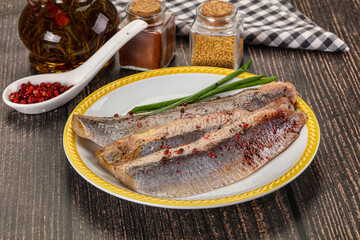 Salted marinated herring fillet with spices