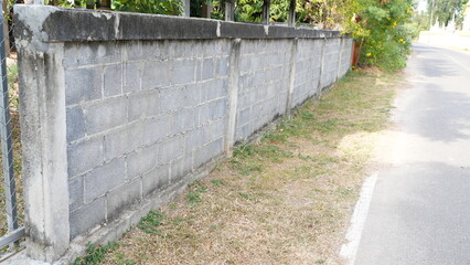 Gray Concrete Wall with Greenery Alongside a Rural Roadside Path