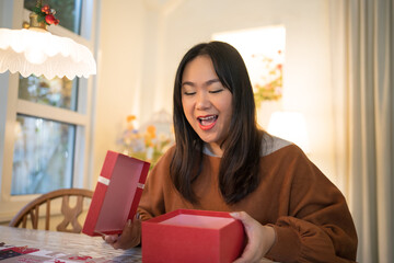 Happy excited asian woman hands holding Christmas gift box. cheerful girl packing Xmas present or open box xmas new year birthday gift.