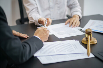 Legal counsel presents to the client a signed contract with gavel and legal law. justice and lawyer...