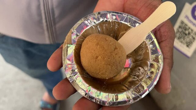 Close up shot of Nolen gur Rosogolla held in hand.