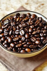 A close-up of a bowl filled with dark roasted coffee beans, showcasing their rich color and texture.