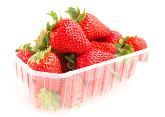 Fresh appetizing strawberries in a plastic tray onwhite background