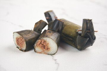 Lemper is a traditional Indonesian snack made from glutinous rice and a savory filling, wrapped in banana leaf