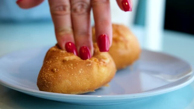 cheese bun woman touches with finger showing freshness of bun Pao de Queijo, traditional cuisine from Minas Gerais, cheese brad