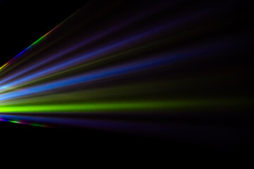colored light beams from reflector through the foggy night sky
