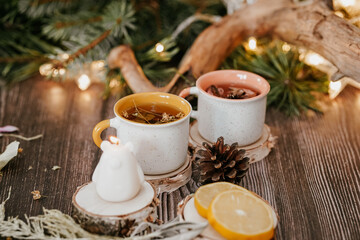 Cozy winter vibes with herbal tea, dried citrus slices, and seasonal decor – Christmas lights and fir tree branches