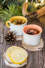 Cozy winter vibes with herbal tea, dried citrus slices, and seasonal decor – Christmas lights and fir tree branches