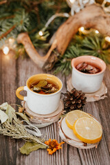 Cozy winter vibes with herbal tea, dried citrus slices, and seasonal decor – Christmas lights and fir tree branches