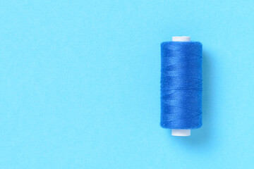 Blue thread spool close-up flat lay top view with copy space for text