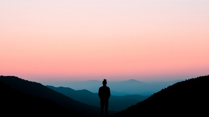 Silhouette of a person at sunset over mountain ranges